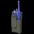 The Condor Patrol Radio Pouch Gen II, a green fabric pouch with flap cover and side openings, securely holds a blue two-way radio—ideal for bushcraft or first responder use.